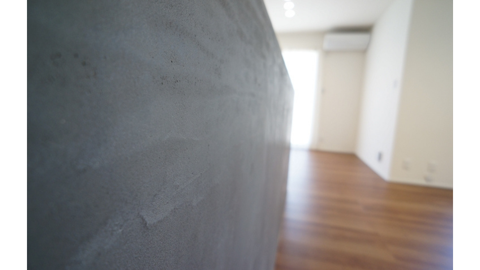モールテックス（MORTEX）特有の、左官職人の手仕事による美しいコテ跡や質感が伝わるキッチンカウンター側面のアップ写真