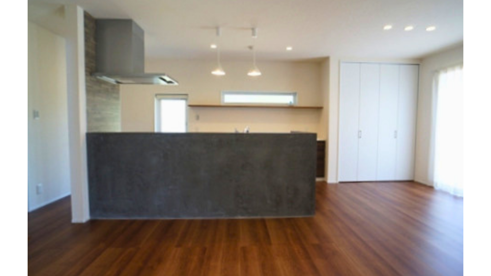ダークグレーのモールテックス（MORTEX）を施工した造作キッチンカウンターと、ペンダントライトが優しく照らすダイニング空間